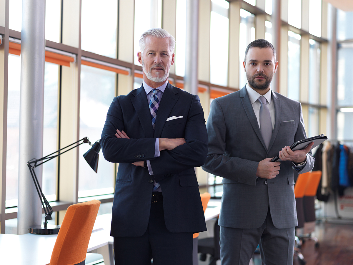 Two men in suits looking serious.